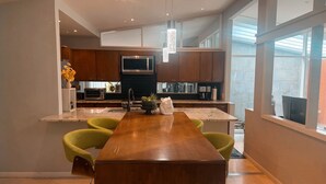 Una cocina moderna con una isla central, electrodomésticos integrados y un amplio ventanal.