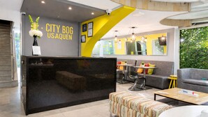 A modern interior with a black reception desk, a yellow accent wall, and a staircase. - Modern loft City Bog Usaquén (Bogotá)