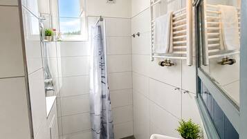 Ein modernes Badezimmer mit Toilette, Waschbecken und Dusche.