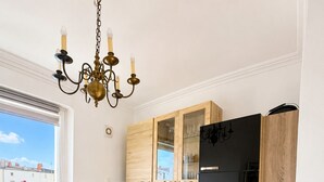 Una cocina moderna con armarios de madera, un refrigerador negro y una zona de comedor con una mesa dispuesta para dos.
