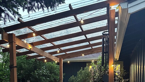 A garden with a wooden pergola, a white bathtub, and a statue. - Spacious 5-bedroom house in beautiful Eugene, AC, hot tub, sauna, large backyard (Eugene)