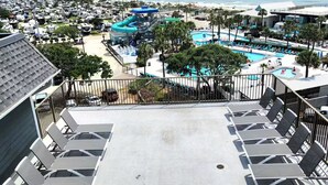 Ein Resort mit Poolbereich, Liegestühlen und Blick auf Strand und Meer.