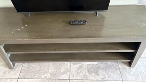 A television on a wooden entertainment center with a remote control on it. - Perfect studio with AC in welcoming TX-3 (Austin)