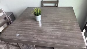 A rectangular dining table with metal legs, a potted plant, and chairs. - Perfect studio with AC in welcoming TX-3 (Austin)