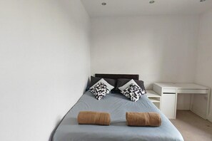 A bedroom with a bed, two pillows, a desk, and a chair. - Spacious Apartment Sleeps 7 Near Central London (London)