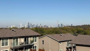 Ein Wohngebiet mit modernen Gebäuden und freiem Blick auf einen entfernten Stadt-Horizont.