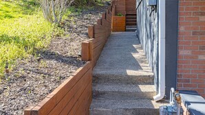 A wooden planter box with a gravel path leading to a building entrance. - Spacious Home with Porch Sleeps 6 Near Pitt & UPMC (Pittsburgh)