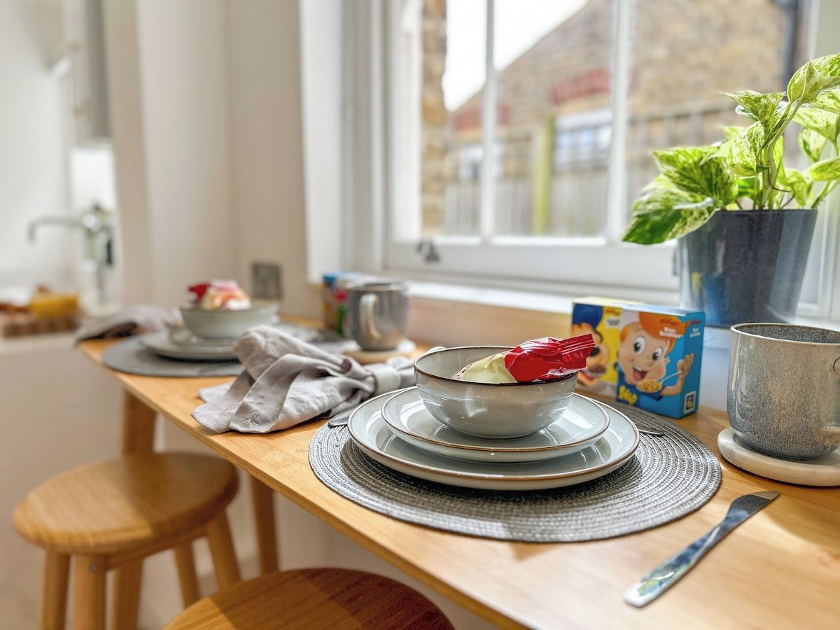 A kitchen counter with a bowl of food, a mug, and a potted plant.