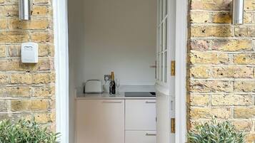 A doorway leading to a kitchen with white cabinets, a countertop, and a bottle of champagne.