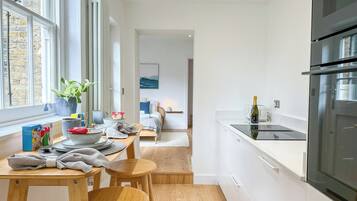 A modern kitchen with a dining area, a view of the city, and a large window.
