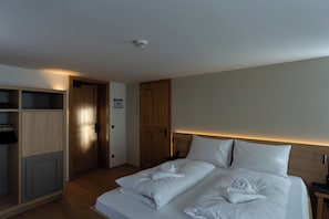 Une chambre d’hôtel avec un lit, une armoire, une porte et une table de chevet.