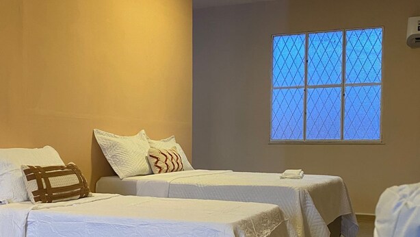 Una habitación con dos camas, una ventana con vistas y una lámpara en el techo.