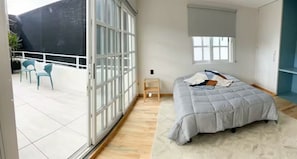 A bedroom with a bed, a small bedside table, a window, and a balcony with chairs. - Art Déco Condesa II Stylish and quiet with rooftop (Ciudad de México)