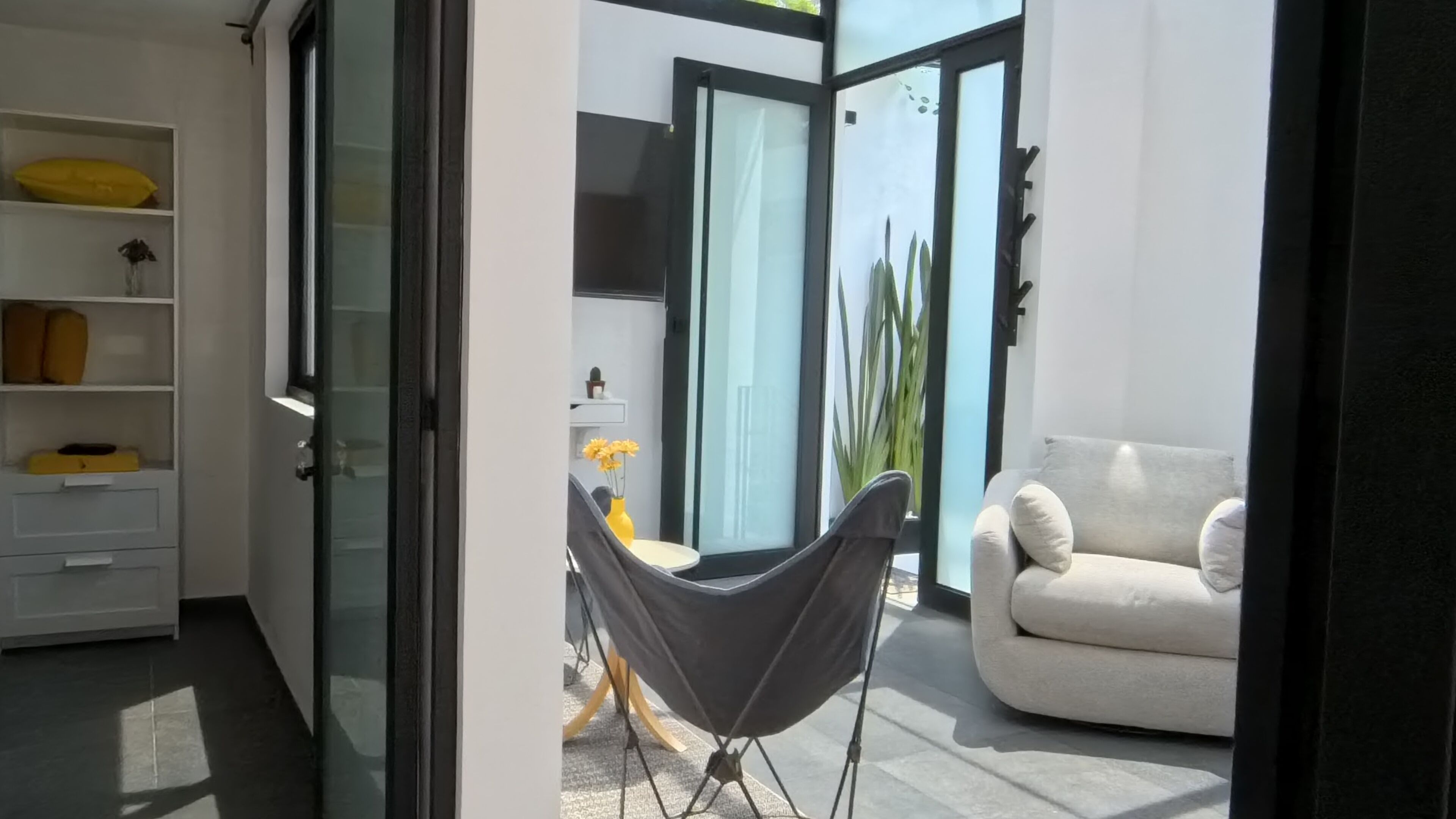 A modern living room with a sofa, a hammock, and a minimalist design.