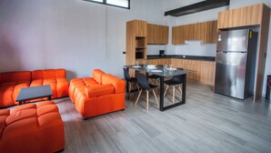 A modern kitchen with wooden cabinets, a stainless steel refrigerator, and a dining area with a table and chairs. - Straw Hat Hostel & RoofTop Bar CDMX (Mexico City)