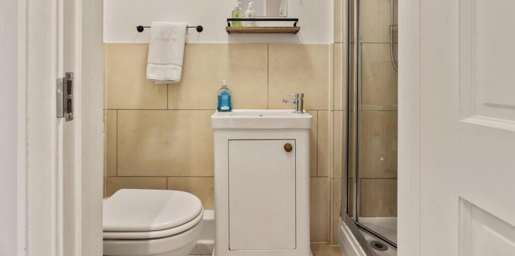 Een badkamer met toilet, wastafel en douche.
