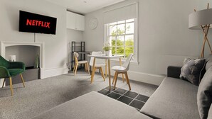 Ein modernes Wohnzimmer mit Flachbildfernseher, Kamin, Essbereich und Sofa.