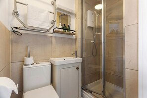 Ein Badezimmer mit Toilette, Waschbecken und einer Duschkabine.
