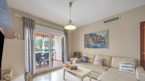 Una sala de estar con un sofá, una mesa y un cuadro en la pared.
