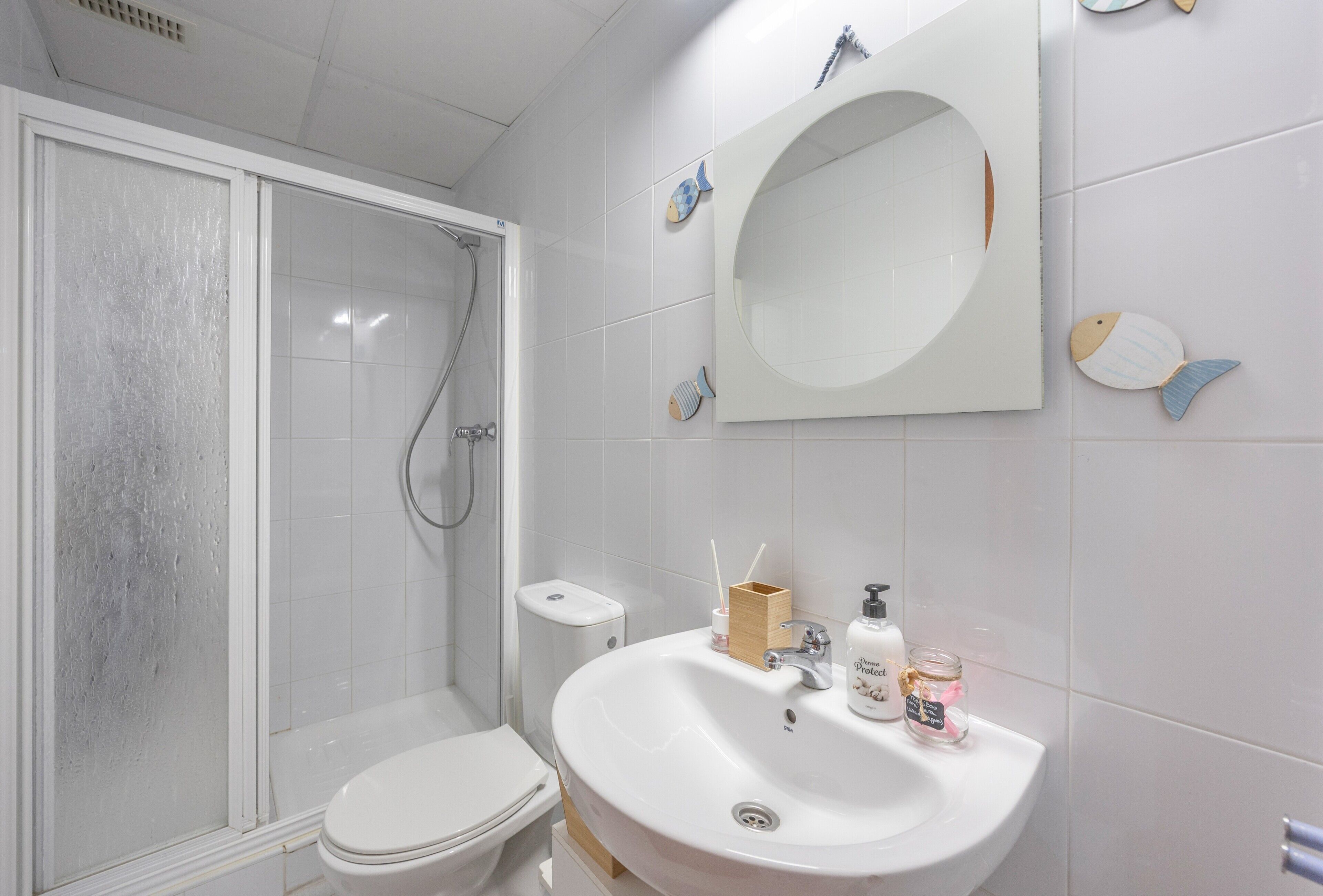 A bathroom with a toilet, a sink, and a shower.