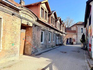 A cobblestone street lined with traditional buildings featuring brick facades and wooden shutters.