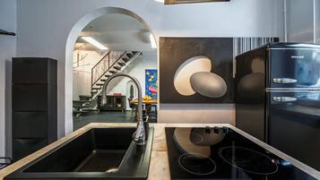 A modern kitchen with a built-in sink, a black stove, and a refrigerator.