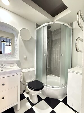 A modern bathroom with a white sink, toilet, and shower.