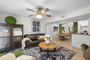 A modern living room with a sofa, coffee table, and a ceiling fan.