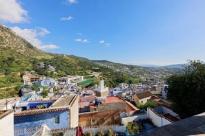 A town with buildings, a hill, and a clear sky.