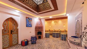 A traditional interior with a patterned floor, a fireplace, a sofa set, and ornate doors.