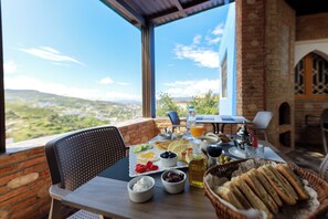 A table set for breakfast with a view of the countryside.