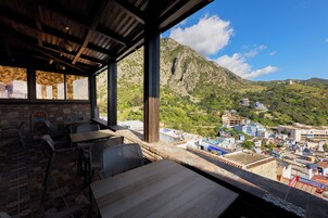 Una terraza con vista a un paisaje montañoso y un pueblo abajo.
