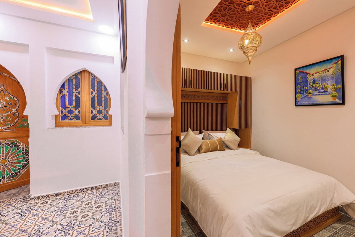 Un dormitorio con una cama, un cuadro y un techo decorativo.