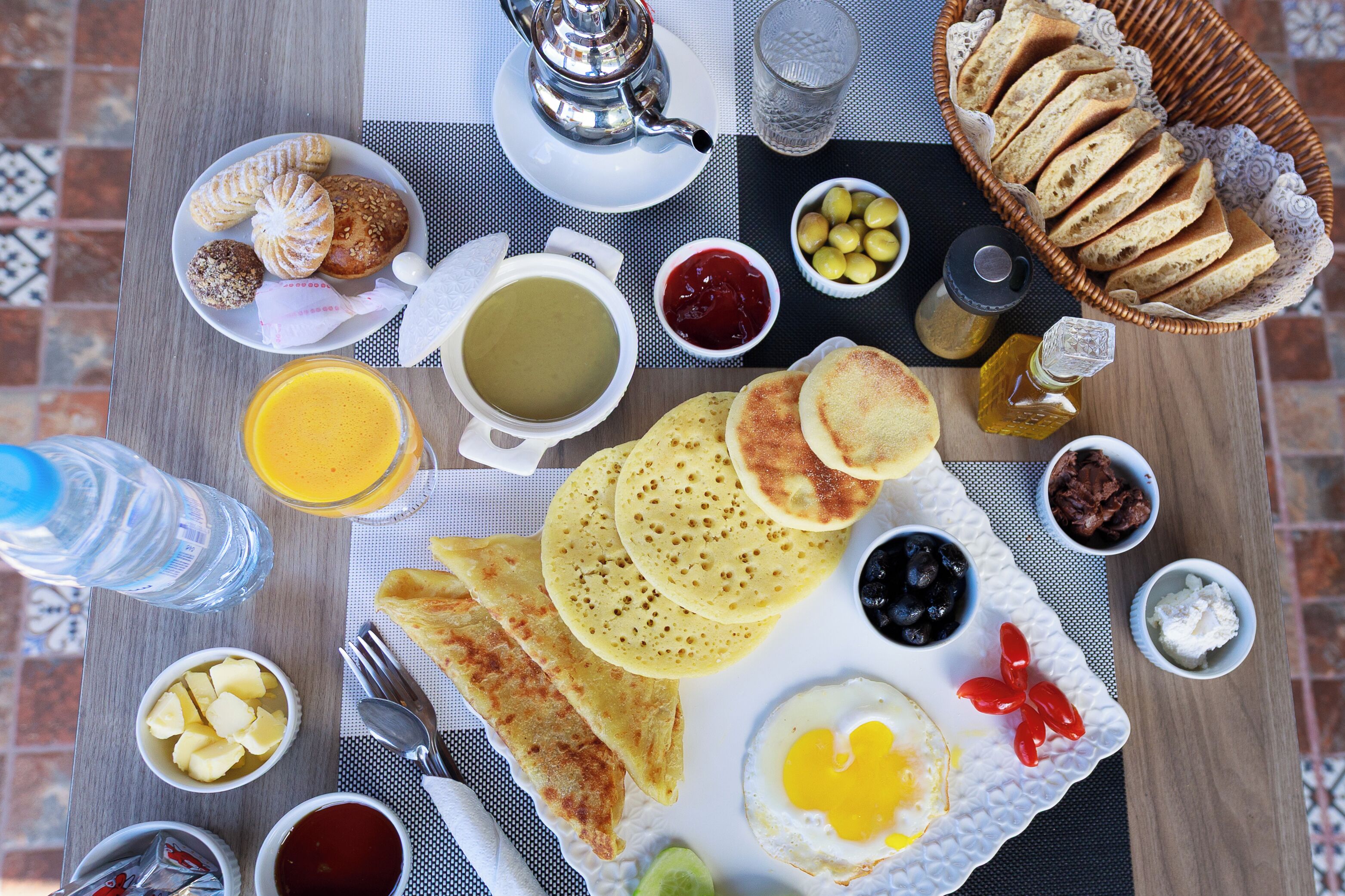 A breakfast table with various food items, including pancakes, eggs, and toast.