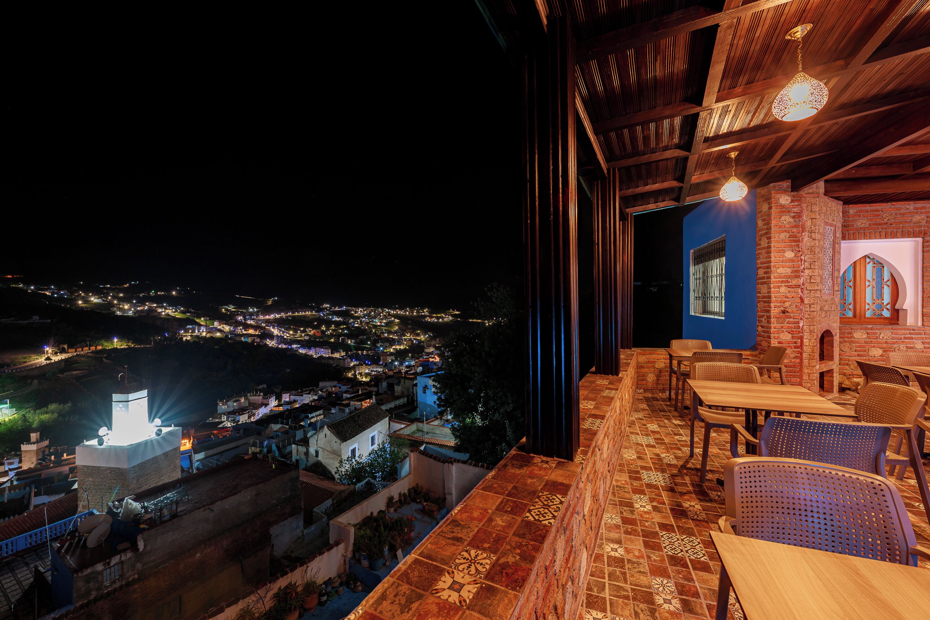 A balcony with a view of a cityscape at night.