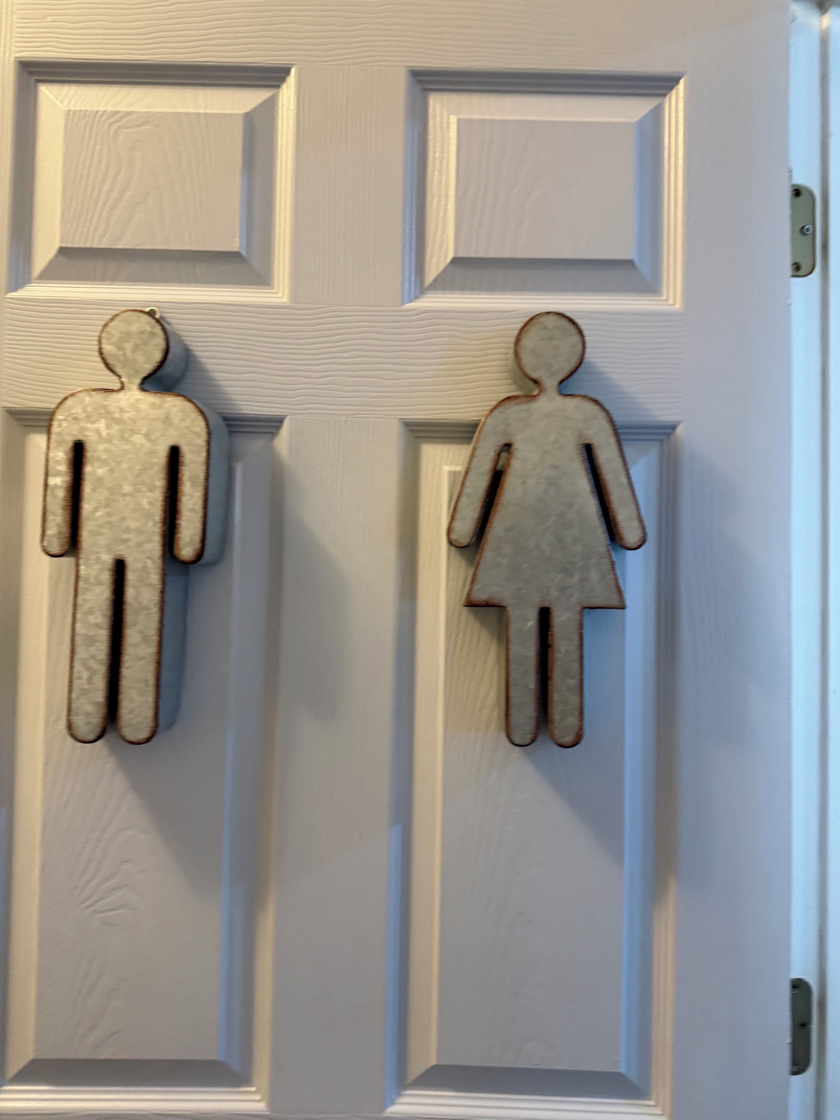 Una porta con due figure intagliate in legno, un uomo e una donna.
