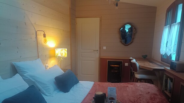 A cozy room with a bed, a table with cups and a tray, a lamp, a mirror, and a window with curtains. - Studio cocoon wood & design - near GR + Le Palais + Plage (Le Palais)