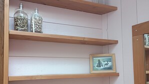 A room with wooden shelves, a framed picture, and a heart-shaped object on the floor. - Studio cocoon wood & design - near GR + Le Palais + Plage (Le Palais)