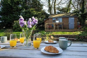 A wooden cabin with a deck, surrounded by greenery. - Ty Mari Crydd, Eglwyswrw (Eglwyswrw)