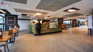 A spacious café area with a counter, seating, and a view of the outside.