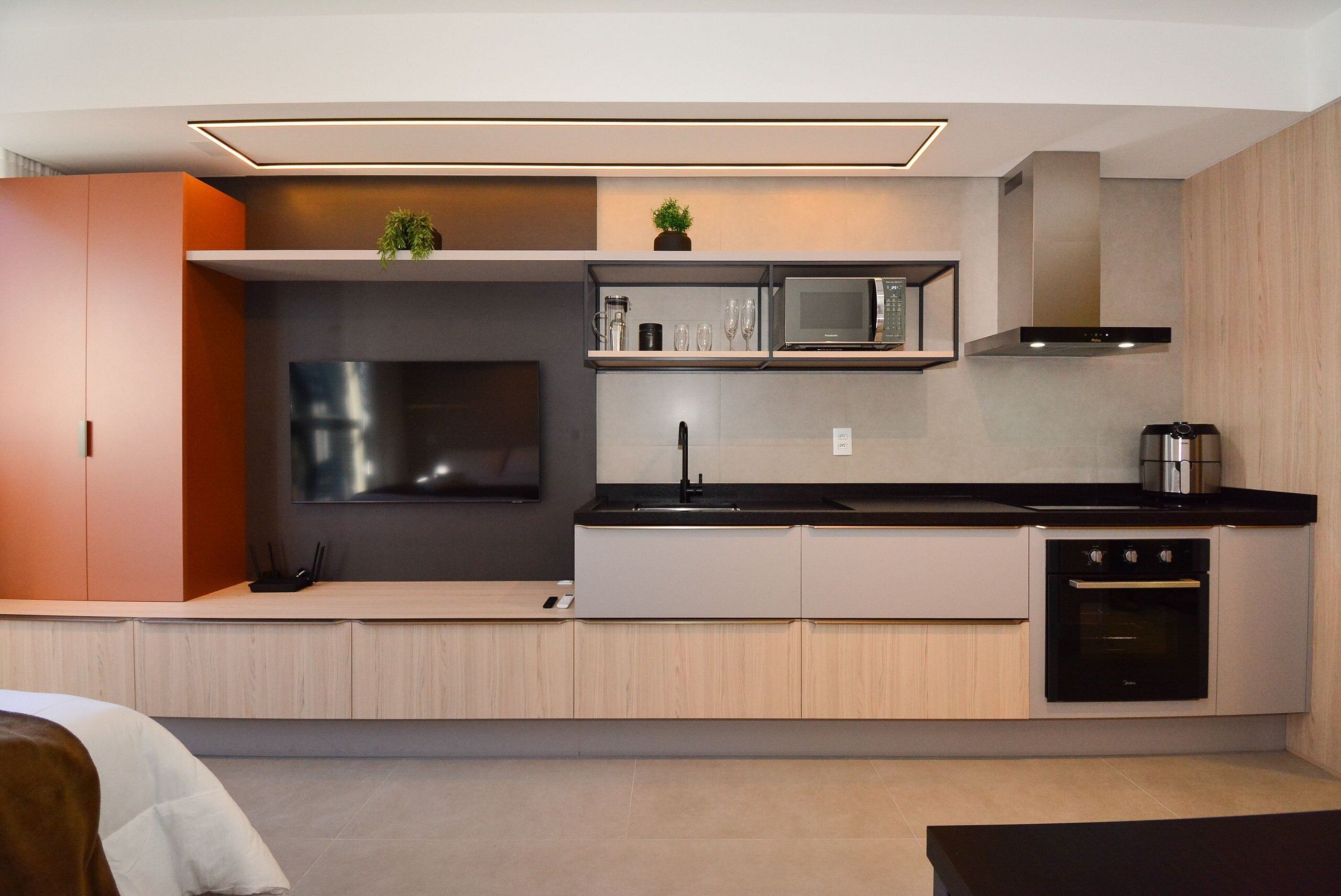 A modern kitchen with a built-in microwave, oven, and sink.
