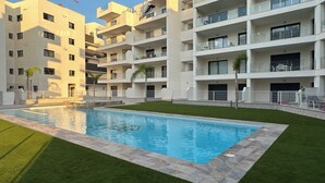 A modern apartment building with a swimming pool, balconies, and a well-maintained lawn. - Casa Anna - Velapi II - Los Alcázares (San Javier)