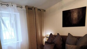 A bedroom with a bed, pillows, a blanket, and a painting on the wall. - Top location! Modern 2-room apartment (Aschaffenburg)