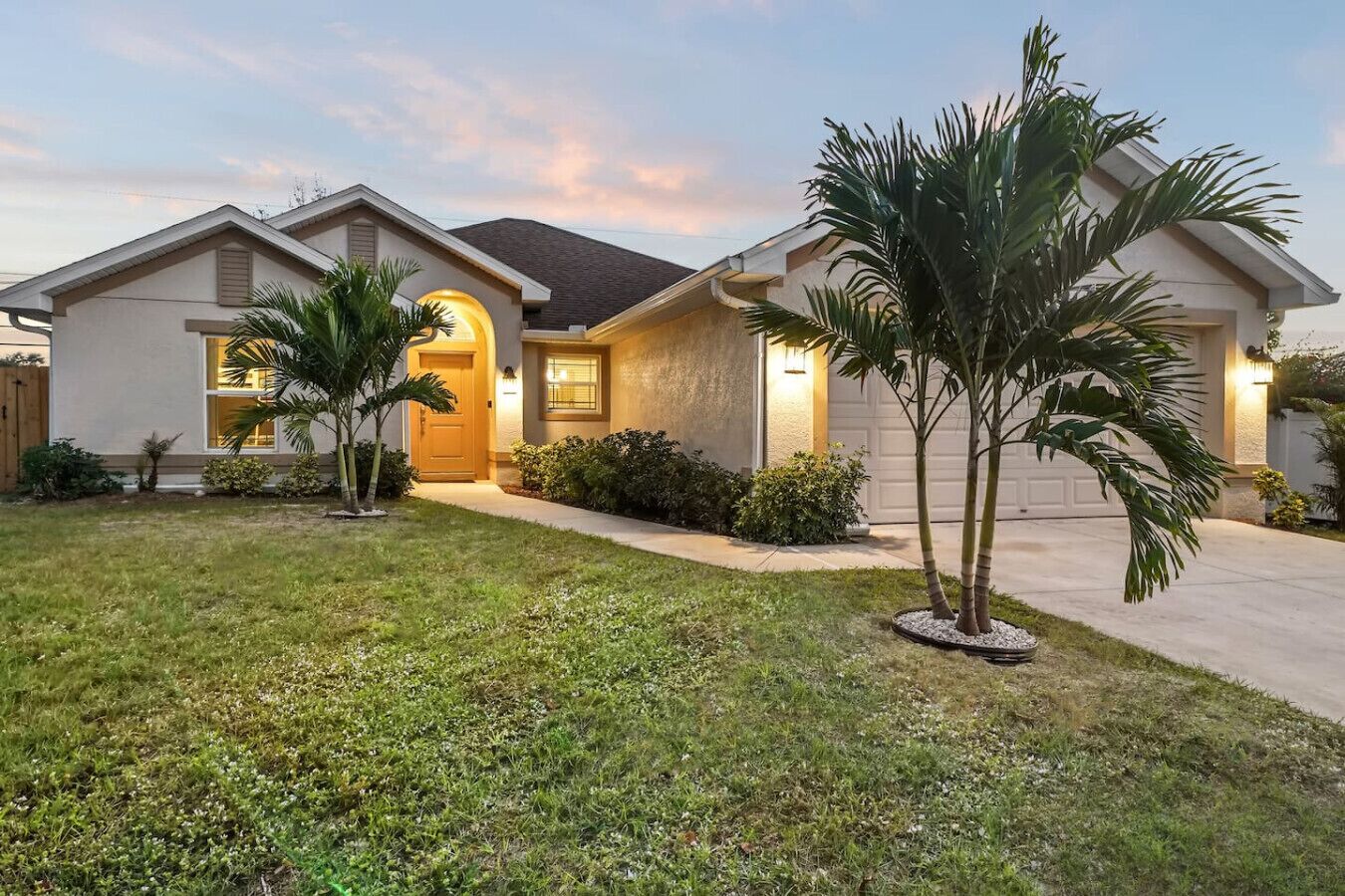 A two-story house with a well-maintained lawn, a driveway, and a garage.