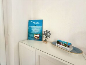 A painting of a boat on water, a metal sculpture, and a 'NO SMOKING' sign on a table. - Schiappacasse 11 - One Bedroom Apartment, Sleeps 3 (Rapallo)