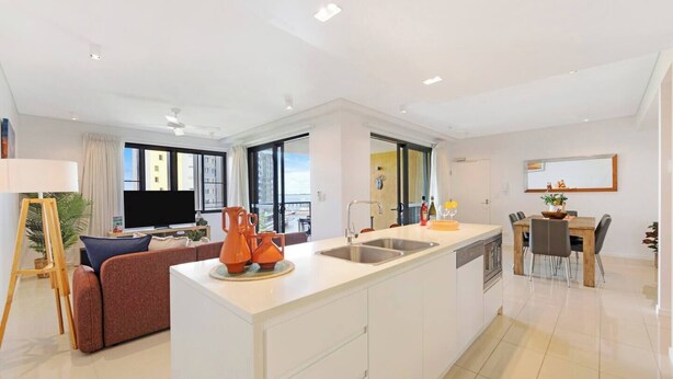 Een modern appartement met keuken, eethoek en zithoek.