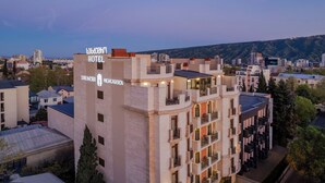 Un hôtel dont la façade porte une enseigne indiquant « HÔTEL » et « HIGHGARDEN ».