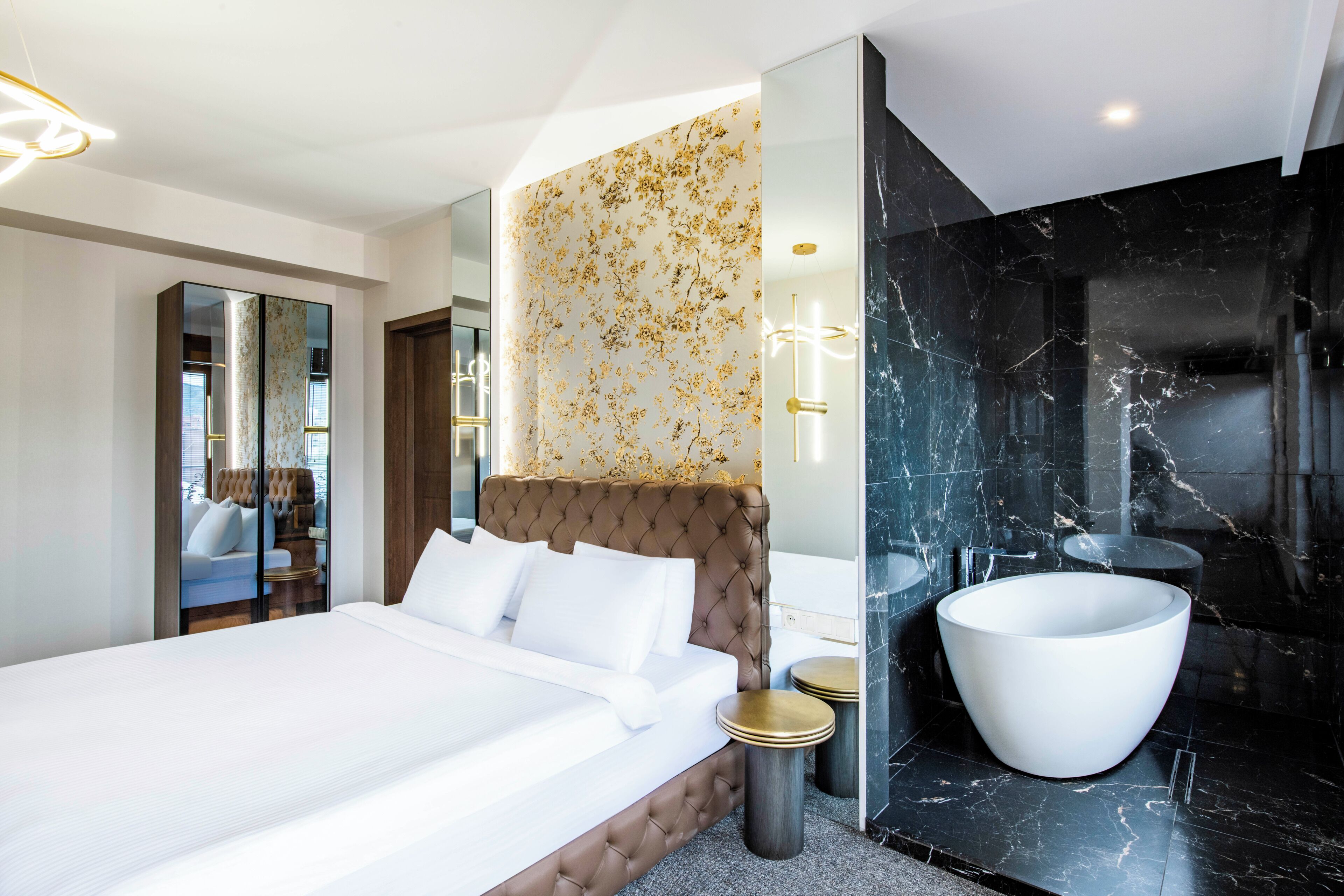Een moderne hotelkamer met een groot bed, een wastafel met een witte wasbak en een ruime badkuip.