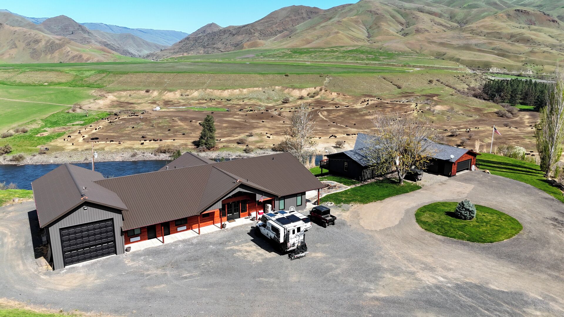 Un bâtiment de style ranch doté d’un garage, d’un espace de stationnement couvert et d’une allée menant à une maison.