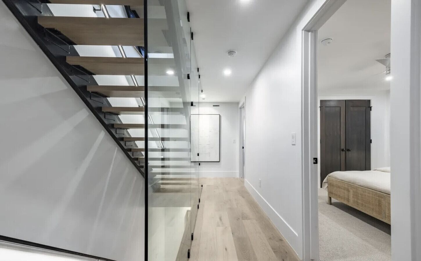 A modern interior with a staircase, a bed, and a wardrobe.